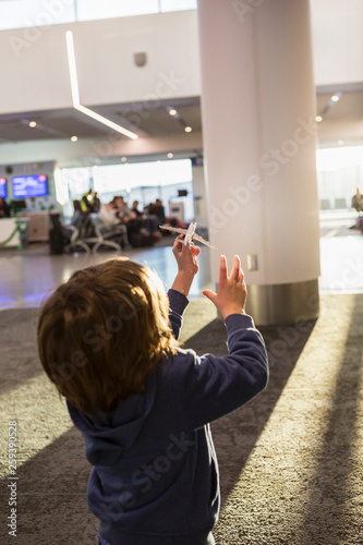 5 year old boy playing with model airplane in airport