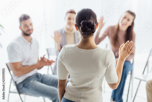 people sitting and raising hands during group therapy session