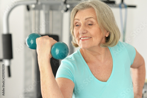 Portrait of cute elderly woman exercising in gym