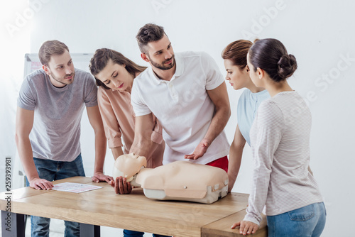 group of people with cpr dummy during first aid training class photo