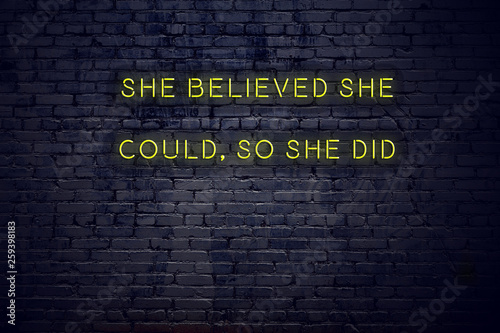 Positive inspiring quote on neon sign against brick wall she believed she could so she did