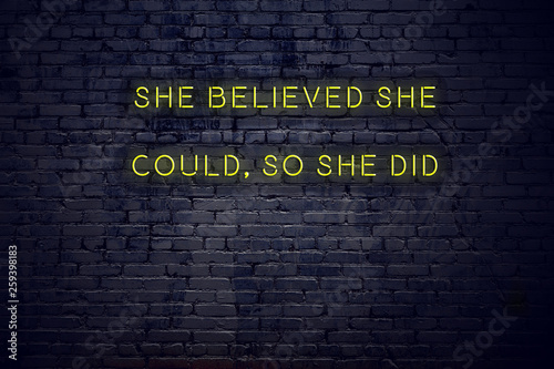 Positive inspiring quote on neon sign against brick wall she believed she could so she did photo