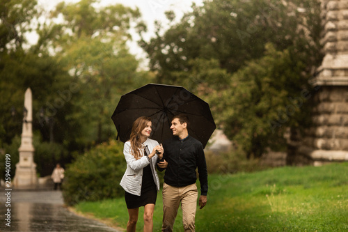 Photography Young couple walking in the park on a rainy day