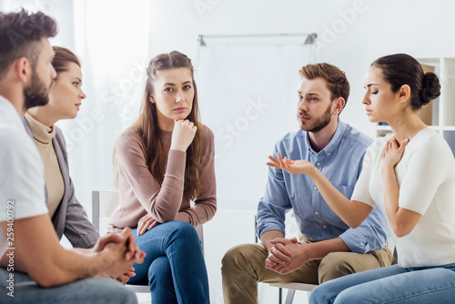 people sitting on chairs and having discussion during support group meeting © LIGHTFIELD STUDIOS