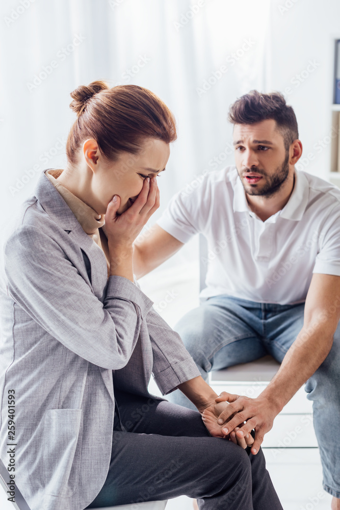 man consoling crying woman during therapy meeting man consoling crying woman during therapy meeting