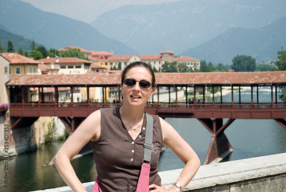 The girl in front of the beautiful bridge of Bassano, Italy