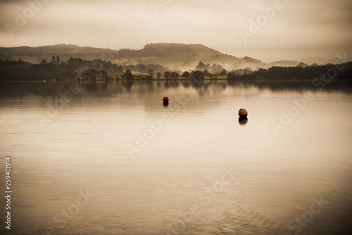 Early morning mist on Lake Windermere the largest natural lake in England. It is a ribbon lake formed in a glacial trough after the retreat of ice at the start of the current interglacial period.  photo