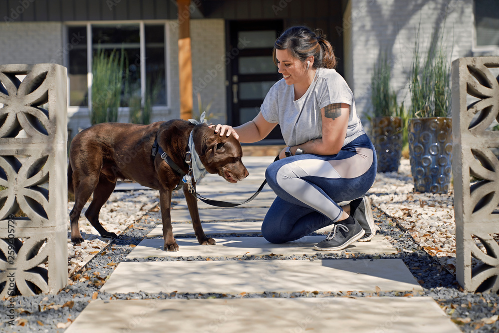 Smiling woman with dog kneeling outdoors Smiling woman with dog kneeling outdoors