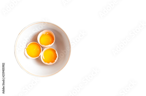 Separated egg yolk in bowl on white background