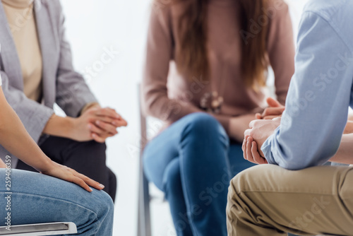 cropped view of people sitting during group therapy session photo