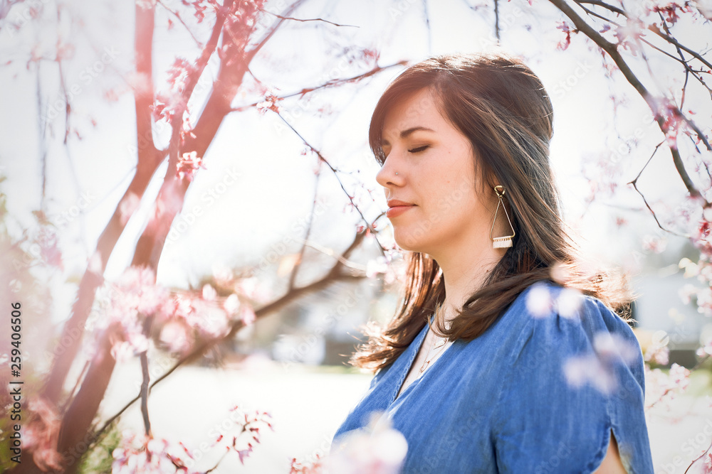 Brunette woman standing near cherry blossom tree Brunette woman standing near cherry blossom tree