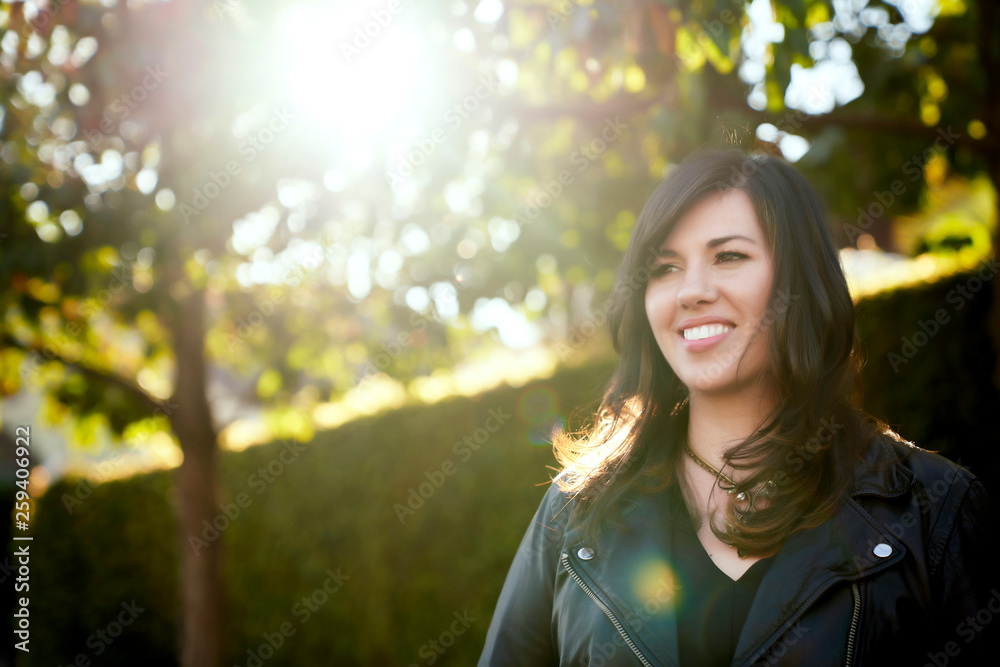 Smiling brunette woman standing outdoors Smiling brunette woman standing outdoors