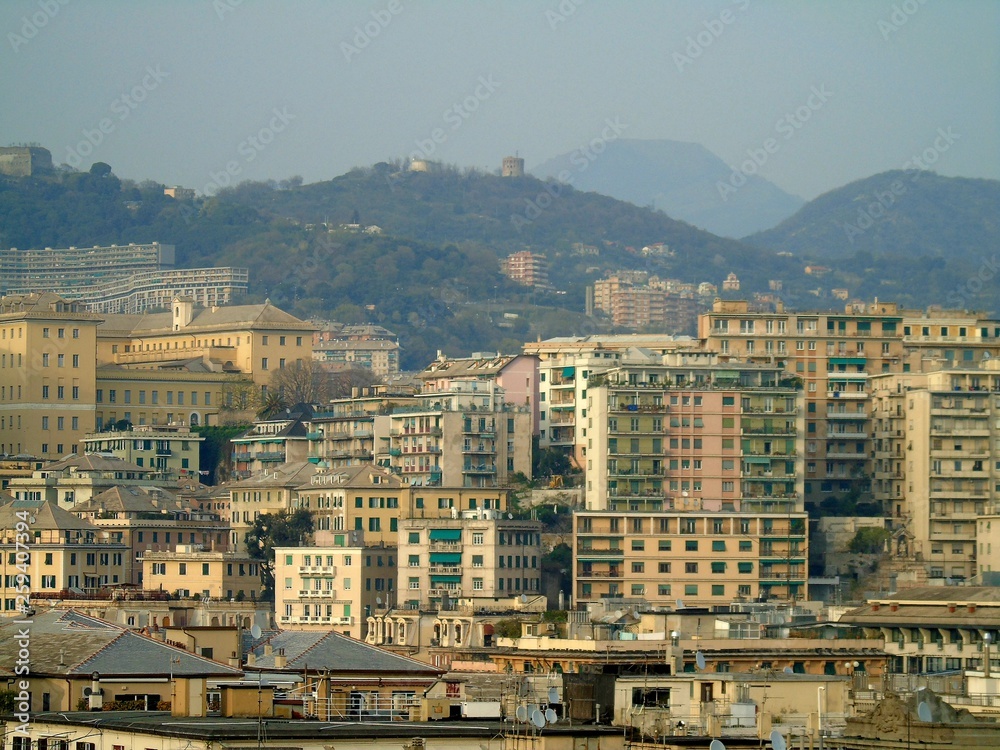 Genova, Italy - 04/02/2019: An amazing caption of the city of Genova from the hills in winter days, with a great grey sky, some tall skyscrapers and beautiful old buildings