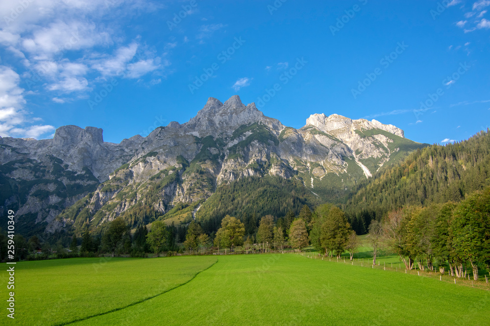 Austrian Verfenveg village Alps mountains autumnal scenery with fog, green meadows and rocks