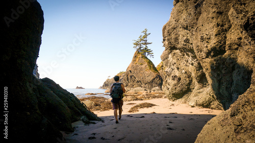 Man hiking along rocky ocean beach