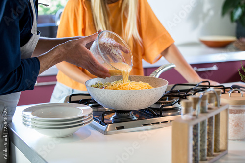Midsection of man pouring batter into saucepan at home photo