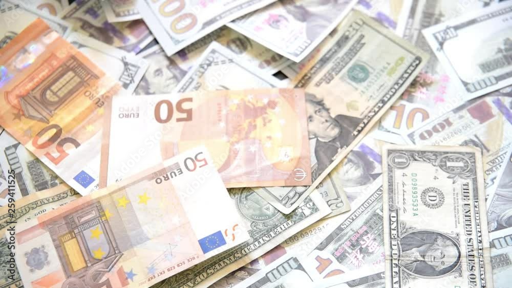 Euro bills falling in front of the camera on a pile of American dollar bills, USA Europe trade war Euro bills falling in front of the camera on a pile of American dollar bills, USA Europe trade war