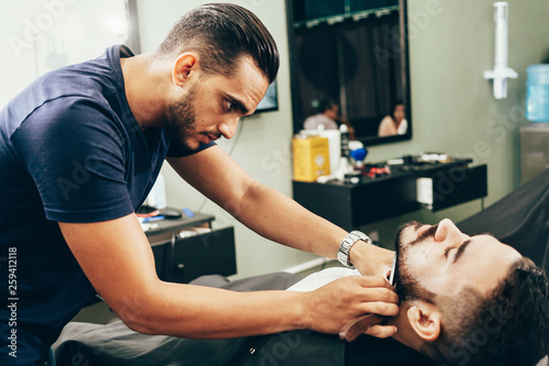 Client during beard and hair grooming in barber shop