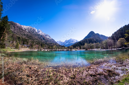 Beach lake Jasna with mountains Razor and Prisojnik in Slovenia photo