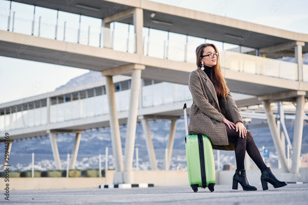 Young beautiful business woman at international airport with suitcase