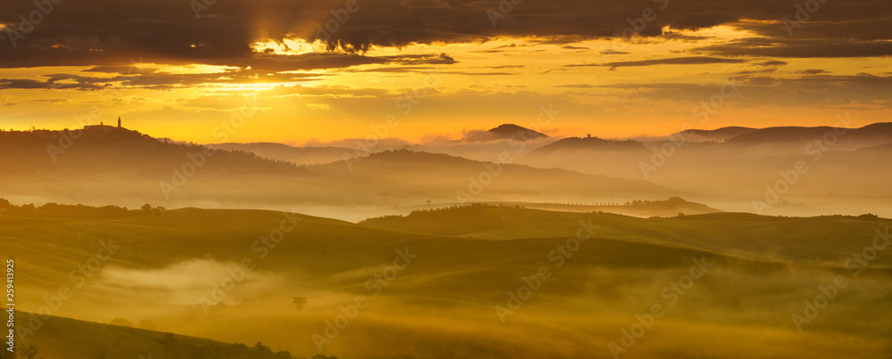 Idyllic view, foggy Tuscan hills in light of the rising sun
