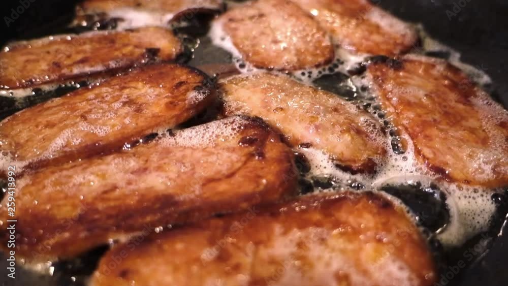 Pork luncheon meat frying in a frying pan. Pork luncheon meat frying in a frying pan.