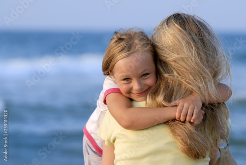 Cute girl hugging her mom on the beach © Trutta