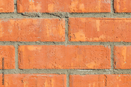Colorful orange brick wall background in a Flemish stretcher bond pattern.Wide brick wall panoramic texture. Home and office design backdrop.architecture wallpaper .terracotta wall