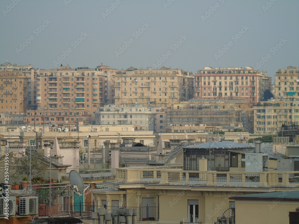 Genova, Italy - 04/02/2019: An amazing caption of the city of Genova from the hills in winter days, with a great grey sky, some tall skyscrapers and beautiful old buildings