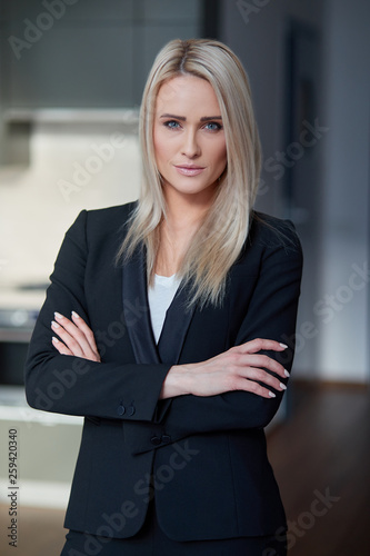 Nice and calm blond, middle age business woman standing at her office