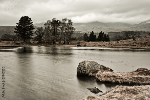 elly Hall Tarn is situated on Torver Back Common to the west of Coniston Water. Set against the dramatic backdrop of the Old Man of Coniston, the small tarn, which measures around 230 by 280 feet is 