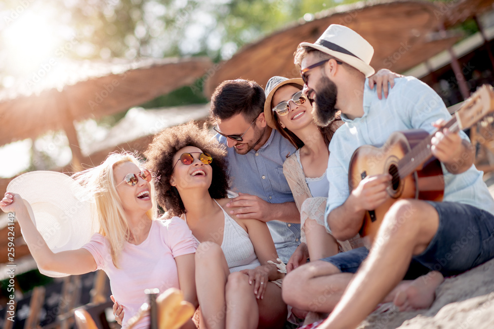 Obraz premium Young friends enjoying at beach party
