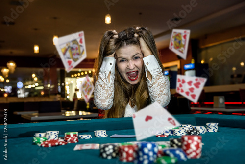 Fotografie Upset woman in casino with falling cards