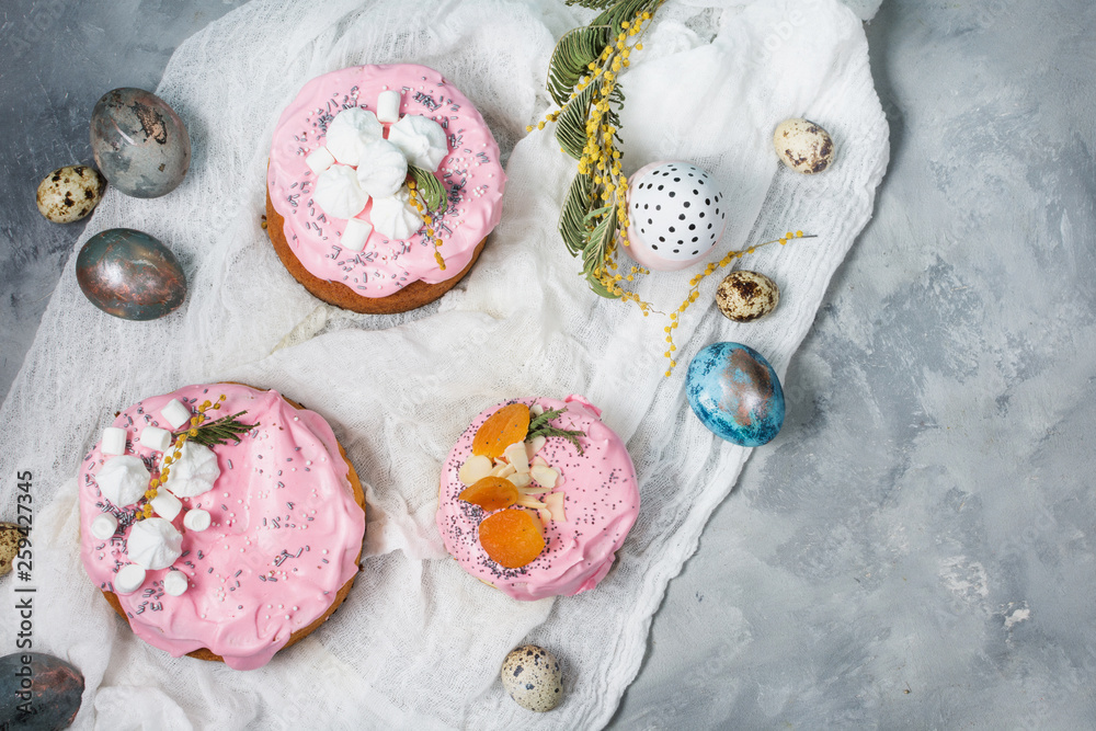 Easter composition with orthodox sweet bread, kulich and eggs on concrete background.