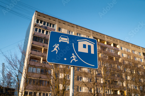 Living sector european road sign in Riga, Latvia with a typical soviet block of flats house building in the background