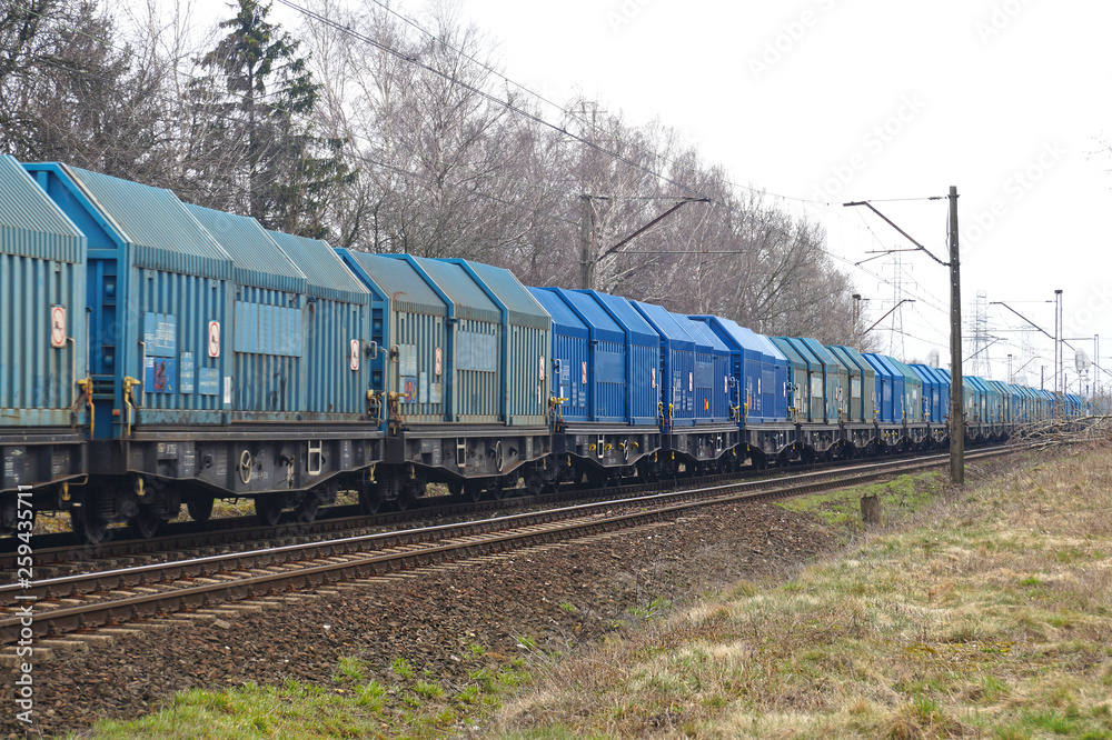 Naklejka premium All wagons in shades of blue. Long freight train.