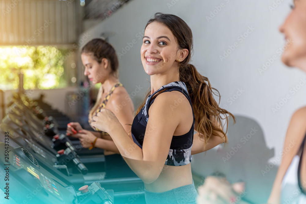 Side view of three attractive sports women on running track. Girls on treadmill Side view of three attractive sports women on running track. Girls on treadmill