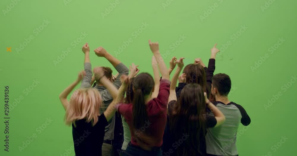 GREEN SCREEN CHROMA KEY Back view group of young people dancing and jumping with hands in the air. 4K UHD ProRes 4444