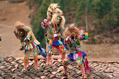 Paucartambo, Cusco, Peru - Circa July 2013: Typical devil rooftop dancers called 'Saqras' at Paucartambo religious festival of Virgen del Carmen. Group of dancers with traditional folkloric clothes. photo