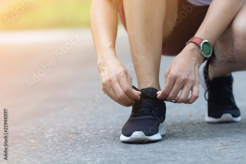 woman tying her shoes while running