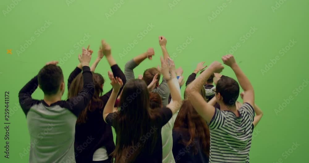GREEN SCREEN CHROMA KEY Back view group of young people dancing and jumping with hands in the air. 4K UHD ProRes 4444