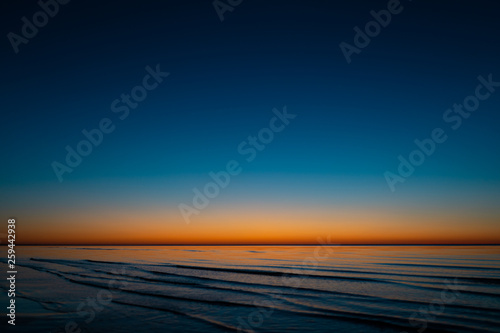 Vivid amazing sunset in Baltic States - Dusk in the sea with horizon illuminates by the sun