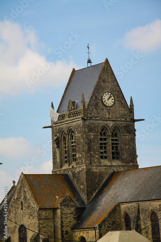 Normandy, France; 4 June 2014: Airborne paratrooper gets stuck on a church in Saint Mere Eglise in Normandy during World War II photo