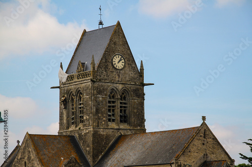 Normandy, France; 4 June 2014: The soldier landed on the steeple of the church of Sainte Mere Eglise photo