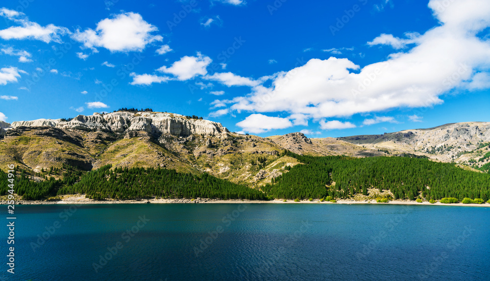 Beautiful landscape photo of turquoise aquamarine lake water and colorful yellow steppes in the mountains of Patagonia, Argentina