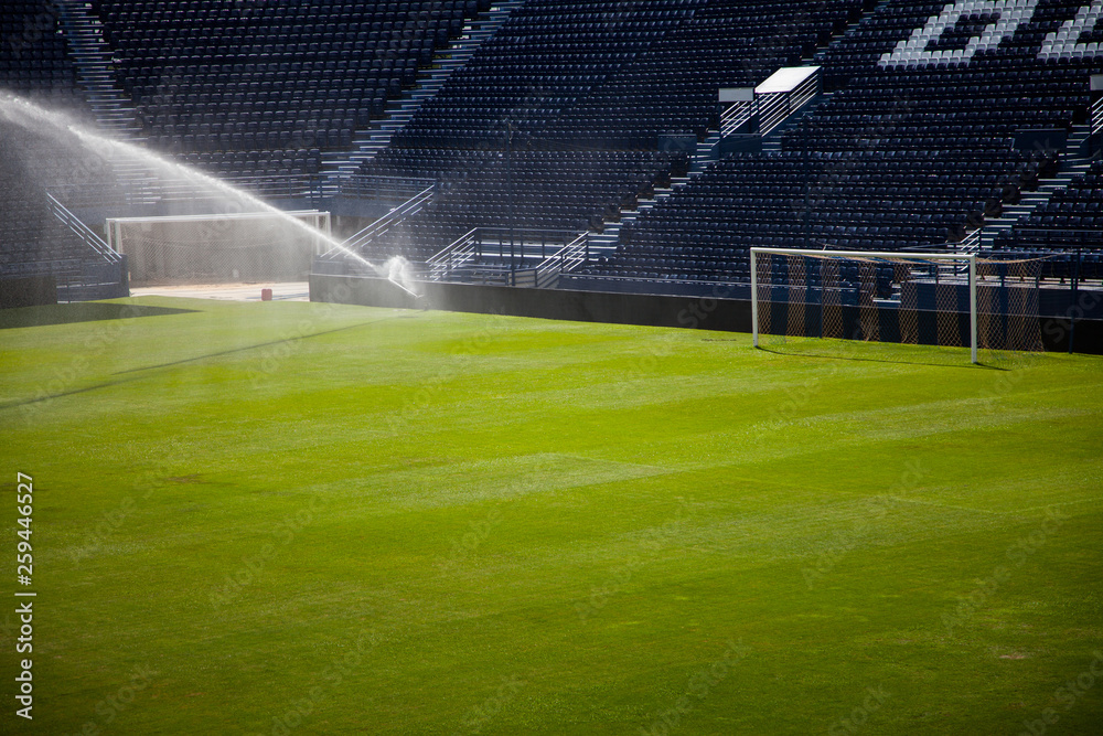 Water jets sprinkling a football Stadium.
