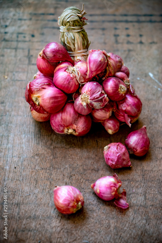 Shallot on the wooden table. It’s a type of onion. Just like onion nutrition and garlic.)