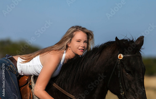 A gorgeous blonde cowgirl riding horse