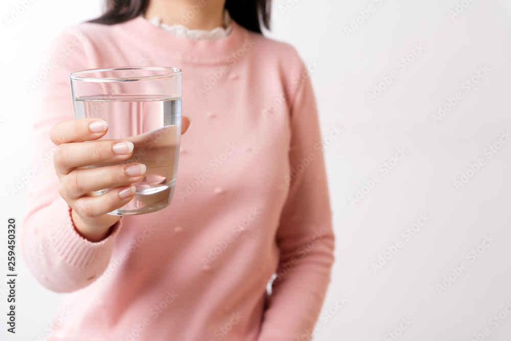 A glass of clean mineral water in woman's hands. Concept of environment protection, healthy drink and healthcare. A glass of clean mineral water in woman's hands. Concept of environment protection, healthy drink and healthcare.