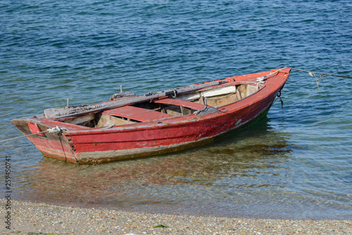 Fototapeta Naklejka Na Ścianę i Meble -  red wooden fishing boat moored on the shore